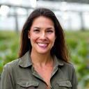 Portrait of Maria Garcia, a greenhouse owner, smiling.